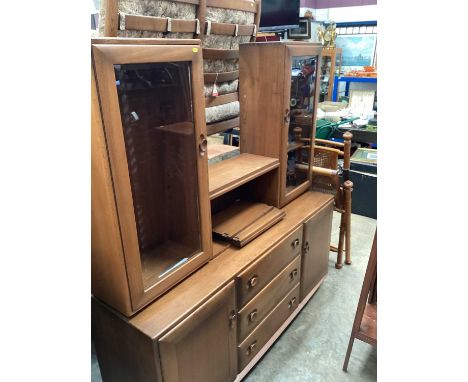Ercol elm two height sideboard with central shelves above flanked by two glazed cabinets, three central drawers and two doors