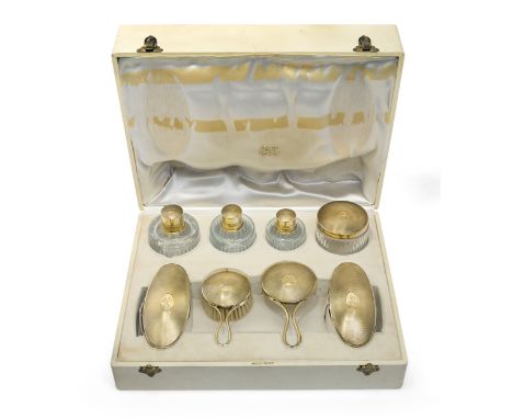 A French silver gilt vanity set, retailed by Odiot, 950 standard, the set comprising: a hand mirror, three brushes, a circula