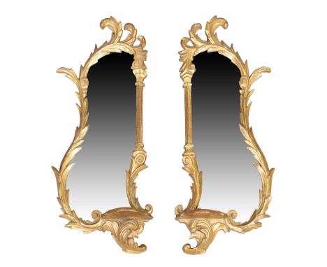 A pair of giltwood mirrors, George III style, third quarter 20th century, the carved scrolling frames with lower shelf, 62cm 