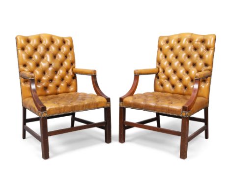 A pair of English mahogany Gainsborough armchairs, in the George III style, 20th century, with tan leather button back uphols