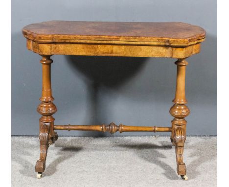 A mid Victorian figured walnut rectangular card table of shaped and moulded outline with quarter veneered folding top enclosi