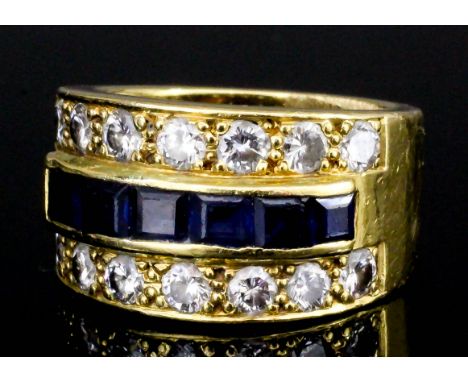 A modern gold coloured metal mounted sapphire and diamond triple band ring, the central band set with six square cut sapphire