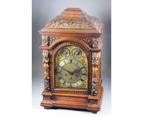A late 19th Century German oak cased mantel clock by Junghans, the 8ins arched brass dial with silvered chapter ring with Rom
