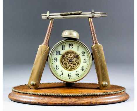 A late 19th/early 20th Century brass plated and oak novelty mantel clock of cricketing interest, the 3.25ins diameter cream e