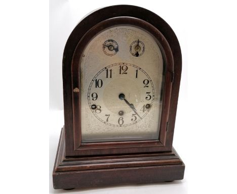 Antique cased round arched mantle clock with silver dial. 34 x 26 x 18.5cm. Has key and pendulum BUT WE CANNOT GUARANTEE THE 