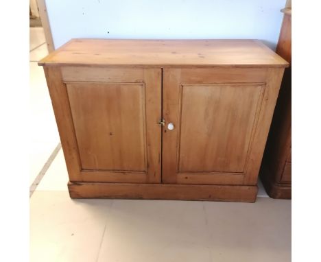 Antique pine 2 door Cupboard, with panelled doors, revealing fitted shelf, on platform base. 122 cm wide, 92 cm high, 55 cm d