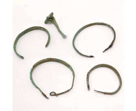 5 x antiquities - 4 bronze bangles and a bronze cloak pin, largest bangle 5.5cm across