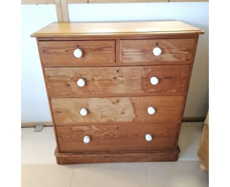Antique pine chest of 2 short and 3 long graduated drawers, with white ceramic knobs, on platform base, 107 cm wide, 112 cm h