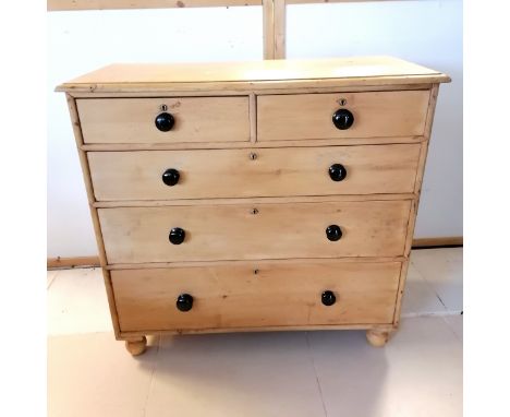 Antique pine chest of 3 short and 3 long graduated drawers with black ceramic knobs, on replaced bun feet. 111 cm wide,  104 
