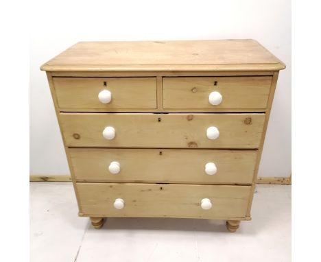 Antique pine chest of 2 short and 3 long graduated drawers, with white ceramic handles, on turned feet. 92 cm wide, 96 cm hig