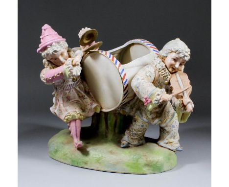 A late 19th Century Continental porcelain group modelled as two children playing instruments, with a lidded drum between them