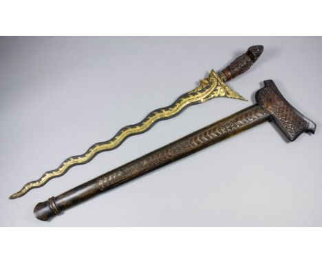 A large Far Eastern Kris, 25ins serpentine blade heavily decorated with brass dragon, heavily carved hardwood grip and scabba