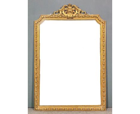 A gilt framed rectangular overmantel mirror of "18th Century" design, with fretted leaf and scroll carved cresting, bead and 