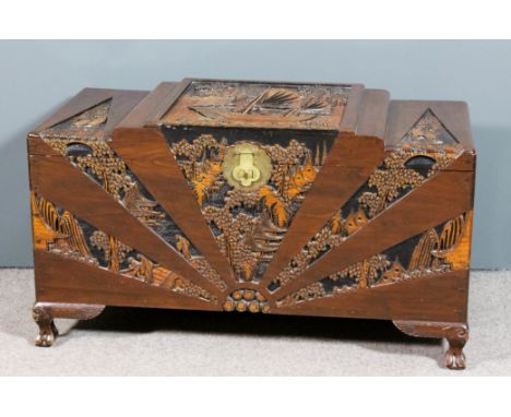 An early 20th Century Chinese camphor wood chest of "Art Deco" design, carved with a river landscape with a junk in full scal