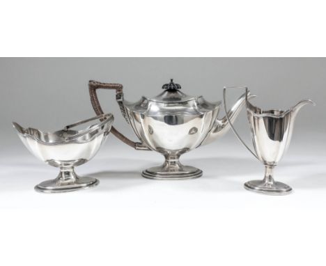 A late Victorian silver oval three piece tea service with shaped and reeded rims, angular loop handles and on oval bases, com