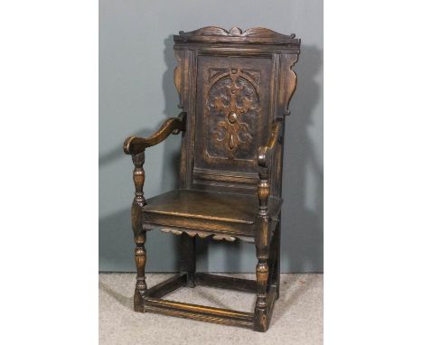 A panelled oak open armchair of "17th Century" design, shaped cresting, panel to back carved with strapwork, with wood seat, 