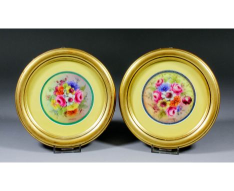 A pair of Royal Worcester bone china circular plaques enamelled in colours with floral sprays and signed by "J. Stanley", 3.7