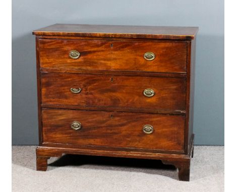 A late Georgian mahogany chest, the top with square edge inlaid with boxwood stringings, fitted three long drawers, on bracke