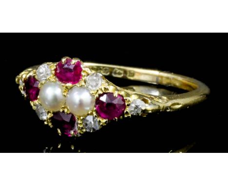 A George V 18ct gold mounted seed pearl, diamond and ruby set ring, the face set with four small rubies, four rose cut diamon