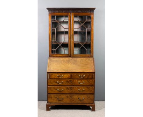 A George III mahogany bureau bookcase, the upper part with dentil cornice and blind fret carved frieze, fitted three shelves 