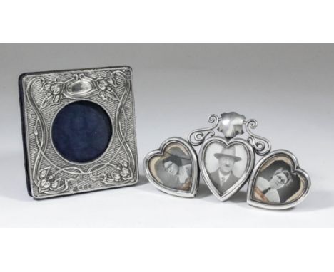 A late Victorian silver triple heart pattern photograph frame surmounted by shield and scroll cresting, 3.25ins x 5.75ins ove