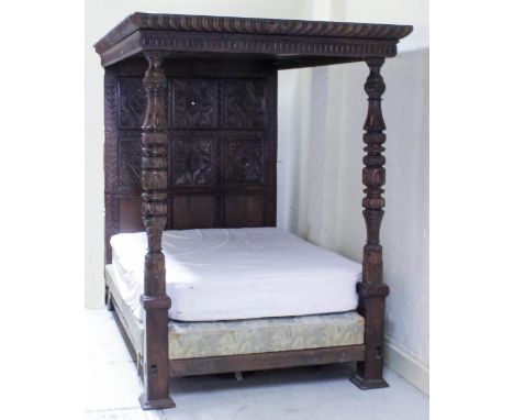 An old panelled oak 4ft 6ins full tester bedstead of "17th Century" design, the panelled headboard inset with six panels carv