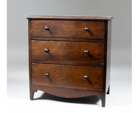 A late Georgian mahogany miniature chest, fitted three drawers, with shaped apron and bracket feet, 10ins wide x 5.5ins deep 