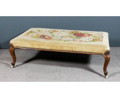 A large Victorian walnut rectangular stool, the top inset with floral needlework panel, within old gold dralon borders and br