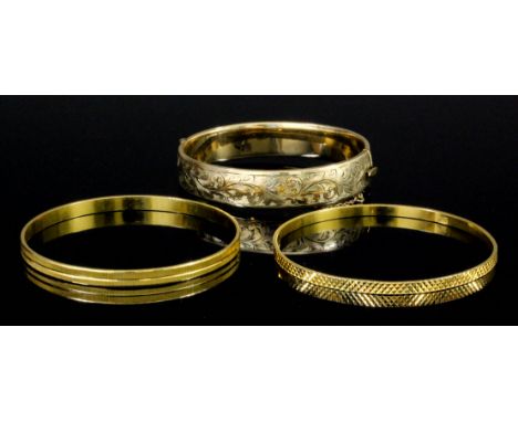 Two modern Eastern  gold coloured metal stiff pattern bangles with engraved faces (gross weight 30.5 grammes), and a modern 9