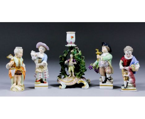 A pair of 20th Century Continental porcelain figures of a young boy holding a bunch of grapes and wine barrel tap and a young