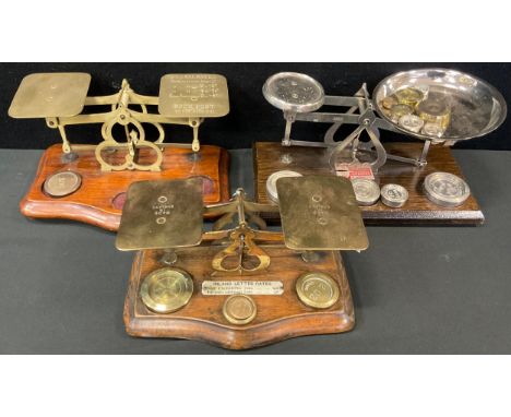 A set of early 20th century brass and mahogany postal scales and weights, serpentine base, c.1910;  another set;  another, mi