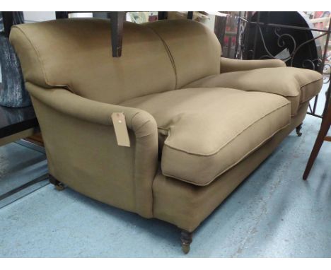 SOFA, Howard style umber, upholstered on castors, 185cm W.