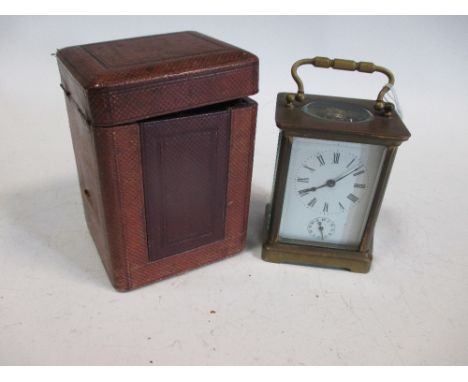 A brass cased mantle clock with leather travelling case  