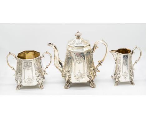 A Victorian Gothic style three piece tea set consisting of tea pot, milk jug and a twin handled sugar bowl, all with ornate f