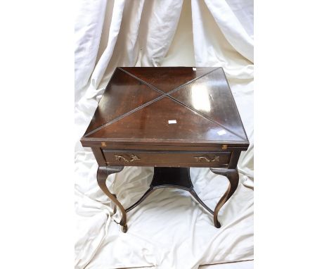 An Edwardian envelope card table in mahogany with green velvet playing surface and concave counter wells.