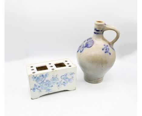 An 18th Century Delftware blue and white flower brick, crudely decorated with flowers, the recessed top with nine holes with 