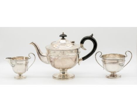 A matched George V silver three piece tea set consisting of tea pot, twin handled sugar bowl and handled milk jug, all on cir