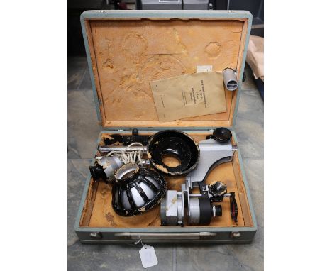 A cased Bell &amp; Howell 16mm projector and empty reels along with a portable photographic enlarger in case, parts inside su