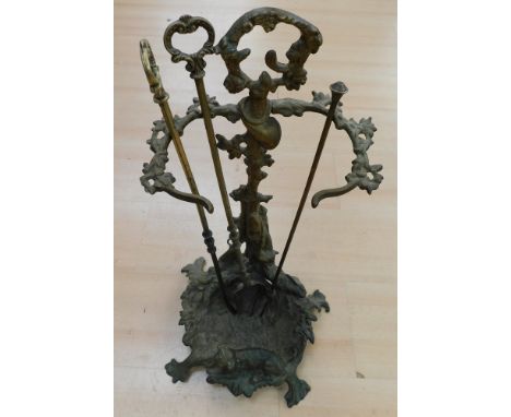 Early 20th Century brass stick stand with hunting dog and rifle detail along with fire irons.