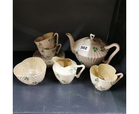 An Early Belleek Irish porcelain teapot, sugar bowl, milk jug and three cups with three saucers.