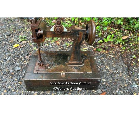 A vintage sewing machine on wooden base / Please bring equipment and labour to assist with removal of all lots. All lots are 