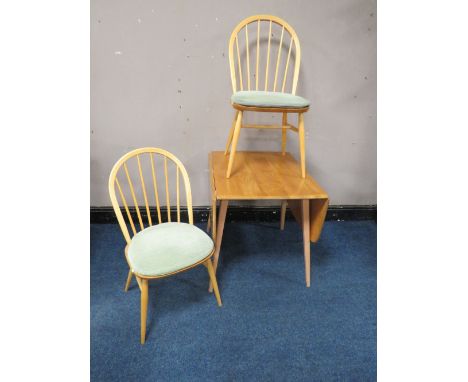 AN ERCOL LIGHT ELM DROPLEAF TABLE, together with two hoop back chairs