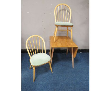 AN ERCOL LIGHT ELM DROPLEAF TABLE, together with two hoop back chairs