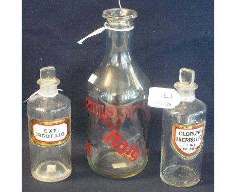 Two 19th Century clear glass apothecary jars with stoppers and painted labels, together with a mallet shaped glass advertisin