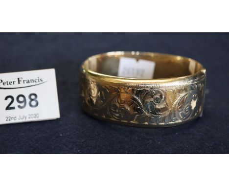 A 9ct gold hollow hinged bangle decorated with scrolling foliage, approx weight total 31.2g. (B.P. 24% incl. VAT)Condition: B
