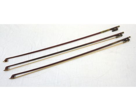 THREE VIOLIN BOWS
each with Mother of Pearl button inlay to the frog, two 73cm long and one 74cm long 