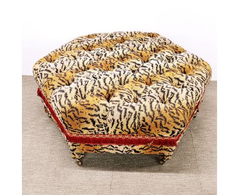An interesting tiger print upholstered and buttoned footstool with castors and tassel edges, 105 x 45cm.