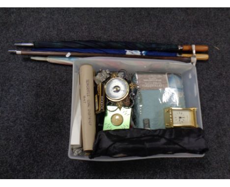 A box containing three umbrellas, a walking stick with pickaxe head handle, barometer, new bedding etc. 