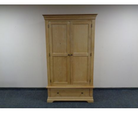 A contemporary light oak wardrobe fitted with a drawer. 