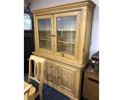 A contemporary light oak bookcase fitted with three drawers and cupboards below. 